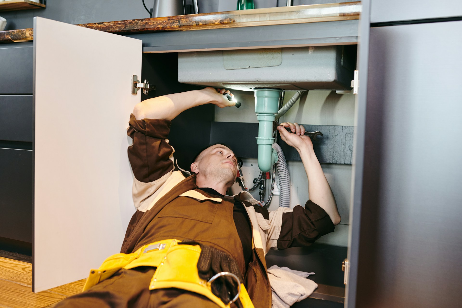 plumber fixing sink pipes