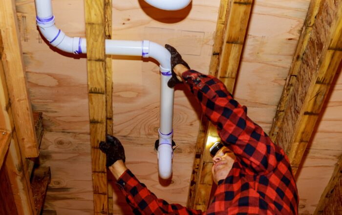 Workers are sewer toilet pipes with PVC joints allows the split to the make PVC pipe coming out the other side of the building